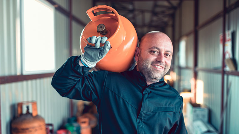 Homem a transportar botija de gás